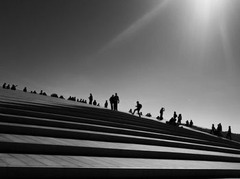 Low angle view of people on steps against sky