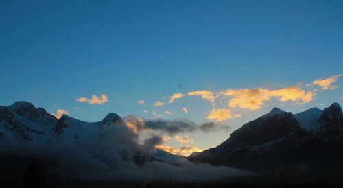 Scenic view of mountains against blue sky during winter