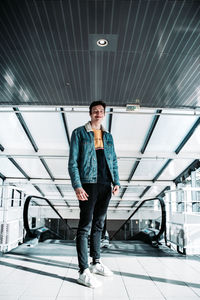 Full length portrait of young men standing on tiled floor