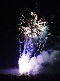 Low angle view of fireworks against sky at night