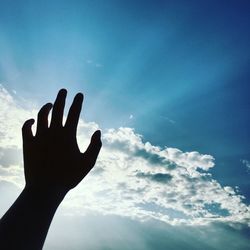 Low angle view of silhouette hand against sky