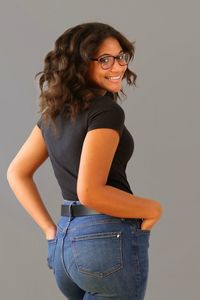 Portrait of smiling woman standing against gray background