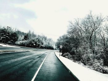 Road amidst trees against sky