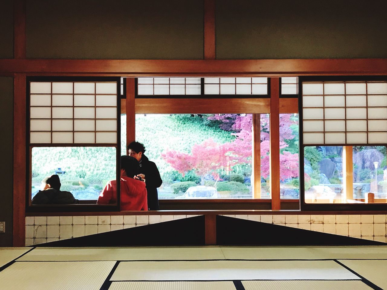 window, real people, indoors, day, lifestyles, architecture, women, built structure, sitting, standing, full length, men, one person, tree, people