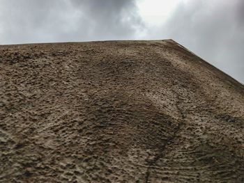 Low angle view of stone wall on desert against sky