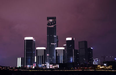 Low angle view of illuminated skyscrapers against sky at night