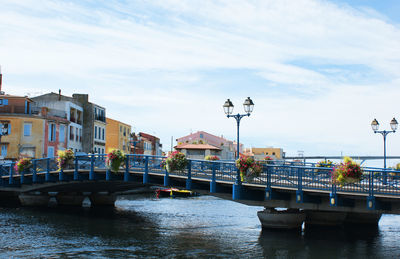 Bridge over river in city against sky