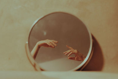 Reflection of woman hands in vanity mirror at home