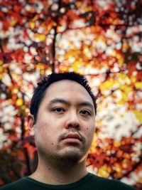 Portrait of young man with autumn leaves