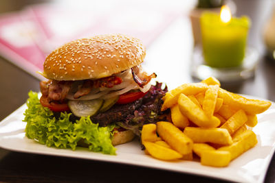 Close-up of burger and fries in plate on table
