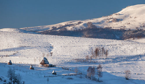 Scenic view of snowcapped mountains against clear blue sky