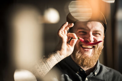 Portrait of a man with a red chili moustache