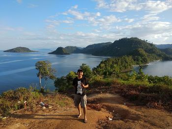 Man standing on lake against sky