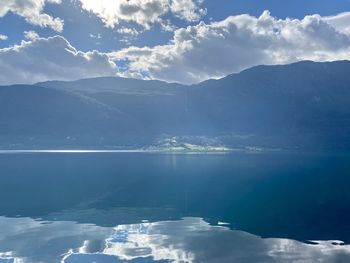 Scenic view of lake by mountains against sky