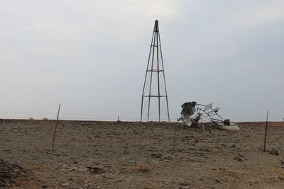 Crane on beach against sky