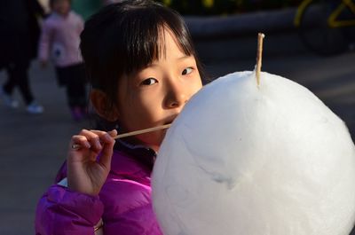 Close-up of cute girl eating candy floss