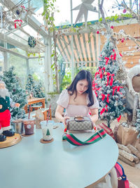 Young woman using mobile phone while sitting in cafe