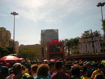 People on street in city against sky