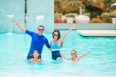 Portrait of family enjoying in swimming pool