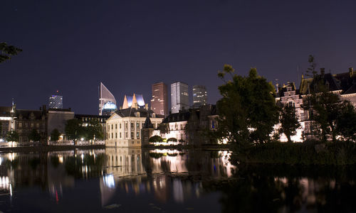 Reflection of buildings in lake at night