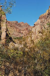 Low angle view of mountains against clear blue sky