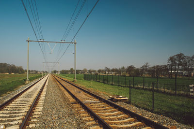 Railroad tracks on field against sky