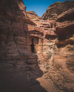 Low angle view of man on rock against sky