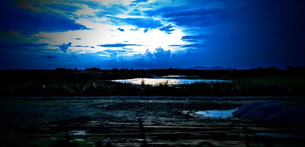 Scenic view of river against sky at sunset