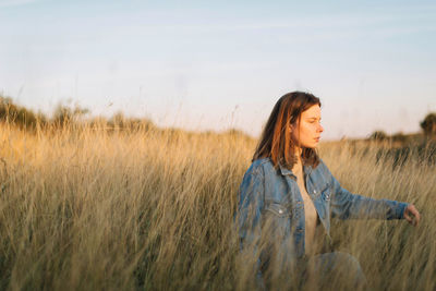 Woman standing on field against sky