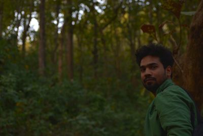 Portrait of young man standing in forest