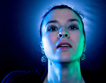 Portrait of young woman in illuminated nightclub