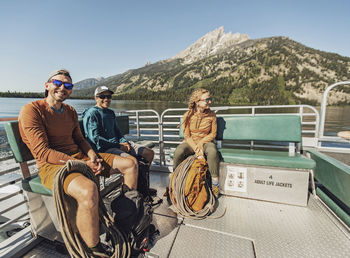 Three rock climbers ride the ferry across jenny lake in the tetons