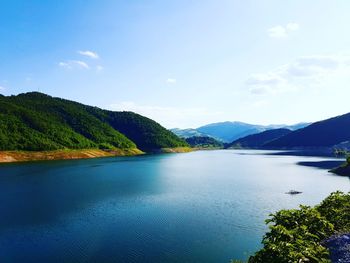 Scenic view of lake and mountains against sky