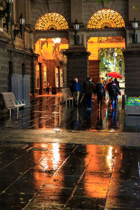 People on wet road during rainy season at night