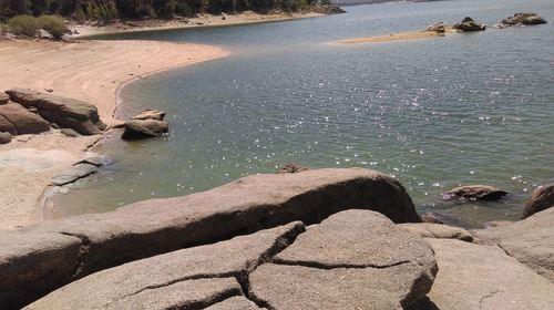 High angle view of sea by rocks on shore