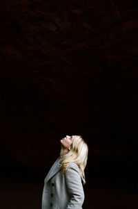 Woman looking up against black background