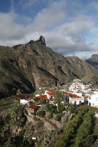 Residential district by mountain against sky