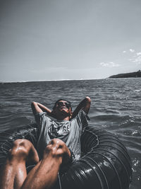 Young man in swimming pool against sea