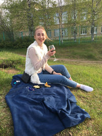 Full length of young woman sitting on field