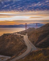 Road amidst mountains against sky during sunset