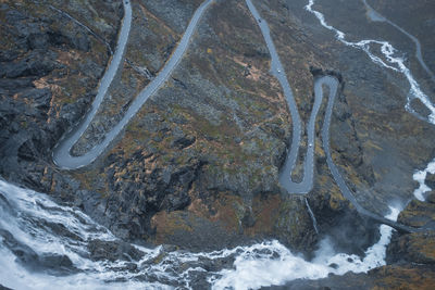 Serpentine mountain road trollstigen with river flowing in norway. aerial view. high angle.