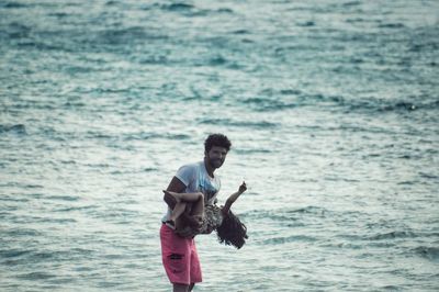 Father carrying daughter at beach