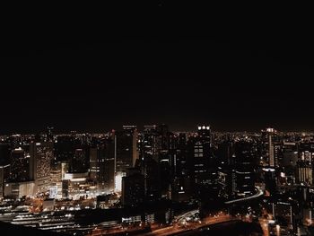 Illuminated buildings in city against sky at night