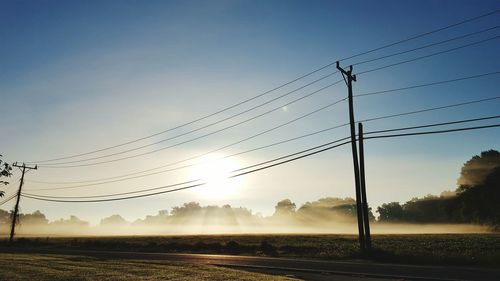 Electricity pylon on field against clear sky