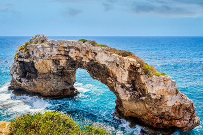 Rock formation in sea against sky