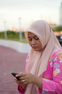 Midsection of woman using mobile phone