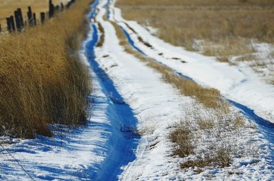 High angle view of frozen river amidst field