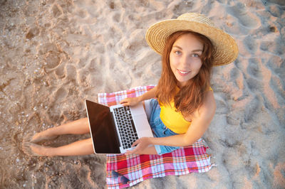 Portrait of young woman with hat on mobile phone