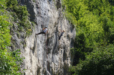 Low angle view of man climbing on rock