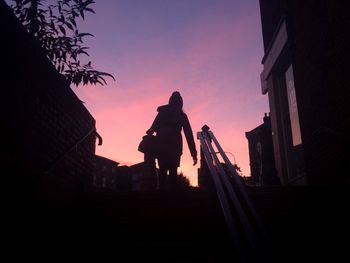 Low angle view of silhouette woman on steps against sky
